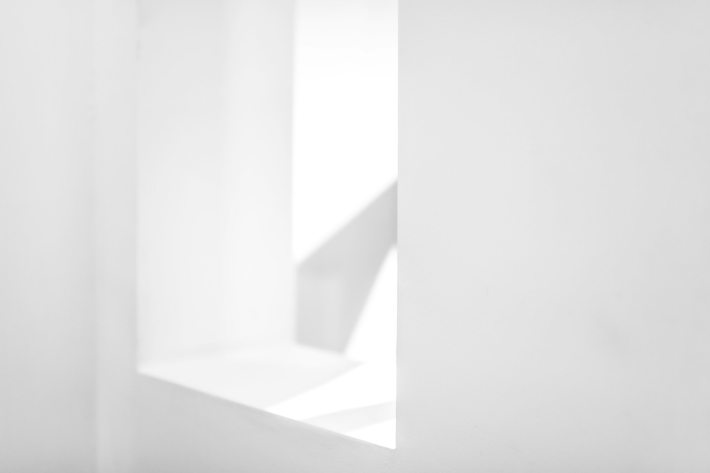 A shaft of daylight falling through a white architectural opening